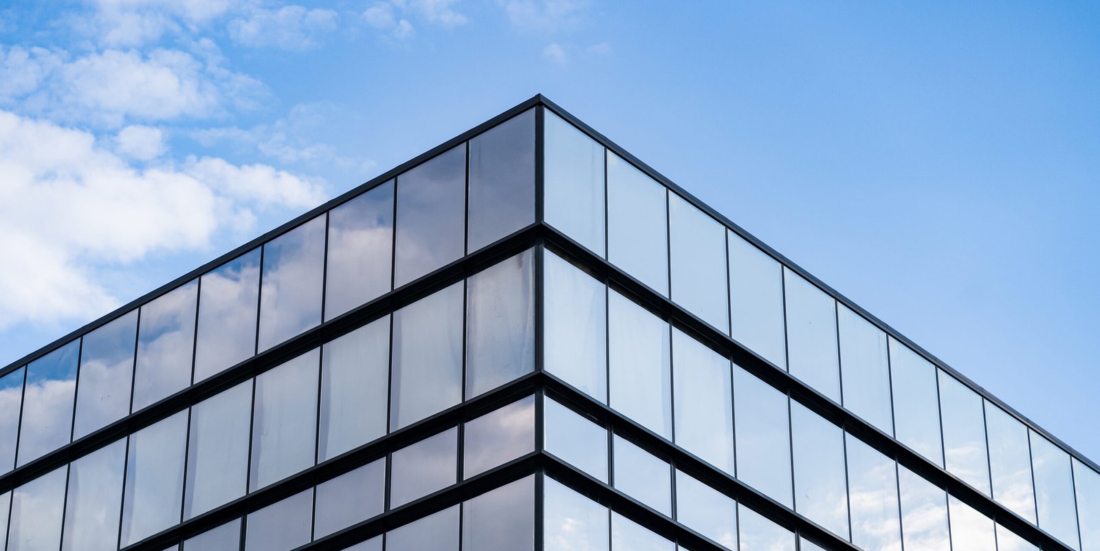 Modern Glass Building Architecture with blue sky and clouds